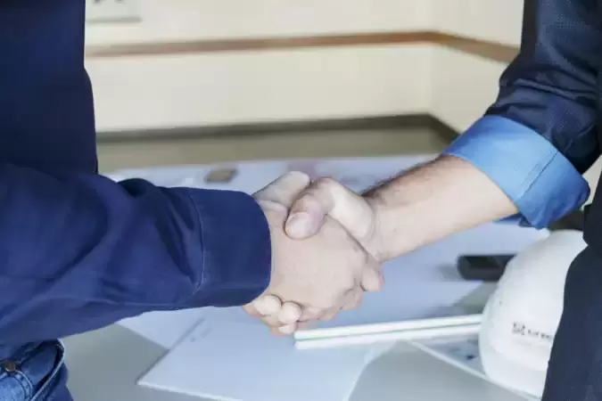 Zwei Menschen geben sich die Hände zum Handschlag